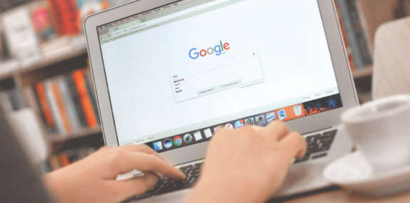 Девушка вводит текстовый запрос через через поиск Google